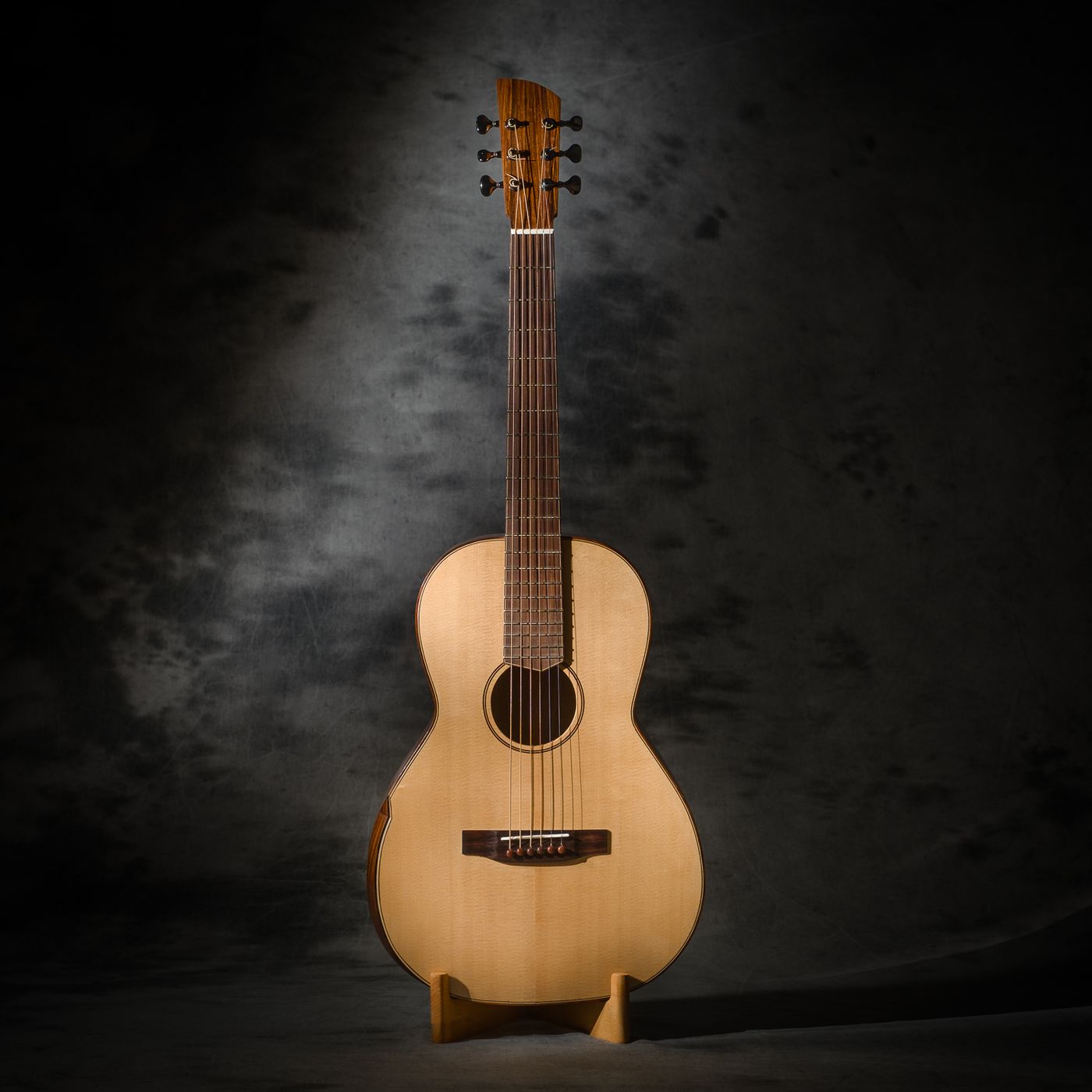 Guitare parlor à cordes acier, vue de face, sur un support en bois